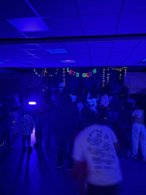 The glow in the dark words Glow Party hung on the stage in the cafeteria for the party. 