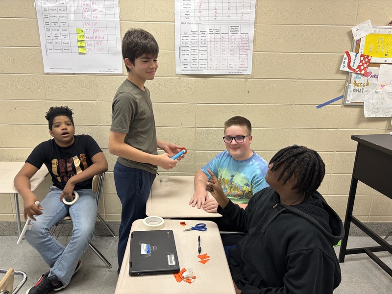 A group of 4 students working on their rocket building activity in science class.