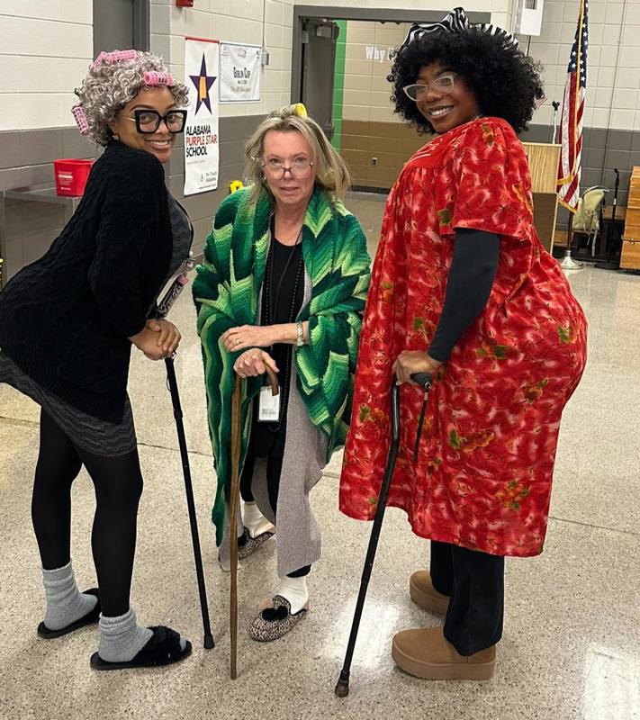 Ms. Kiara, Ms. Sutton, and Ms. Brewer with their canes in the cafeteria.