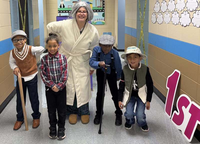 Miss Rafey with some of her 1st grade students acting like they are 100 years old. 