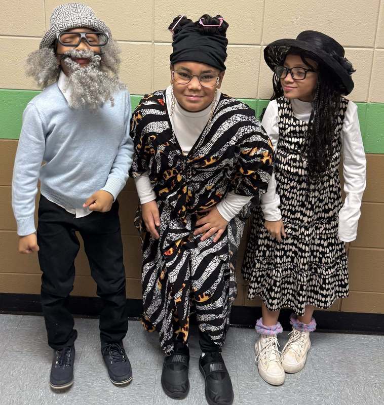 Three 3rd graders in the hallway with their 100 day outfits.