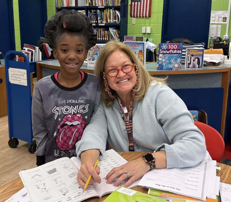Our librarian, Mrs. Nurre, and a second grade working in the library on the 100th day of school.