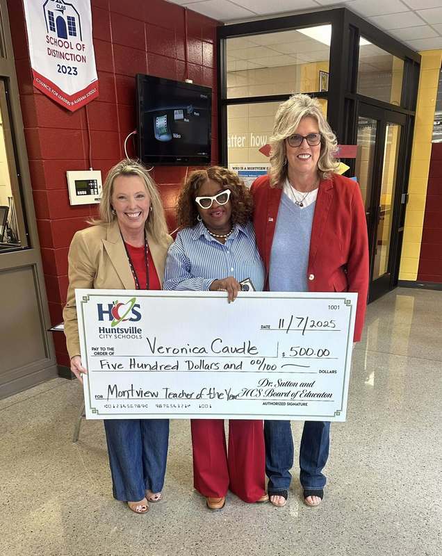 Ms. Caudle holding up her check with our principal, Ms. Sutton, and our Assistant Principal, Ms. Boissel.