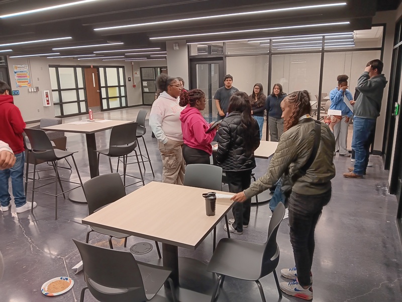 10 students can be seen standing in the Innovation Center that was turned into a Crime Scene discussing and observing the crime scene