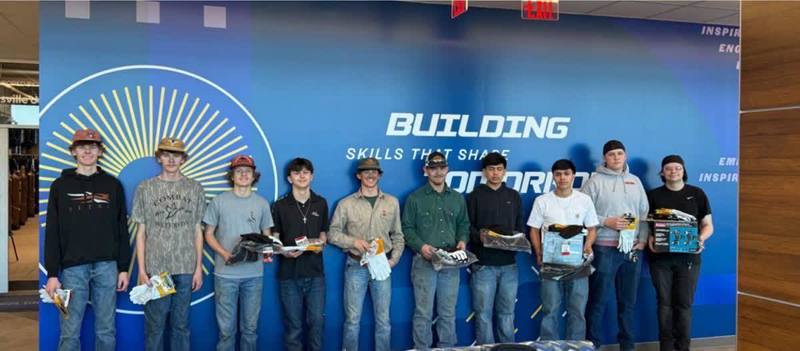 The top 10 winners of the welding competition from from across North Alabama stand in front of the wall in the Center for Technology that says Building Skills that shape tomorrow.