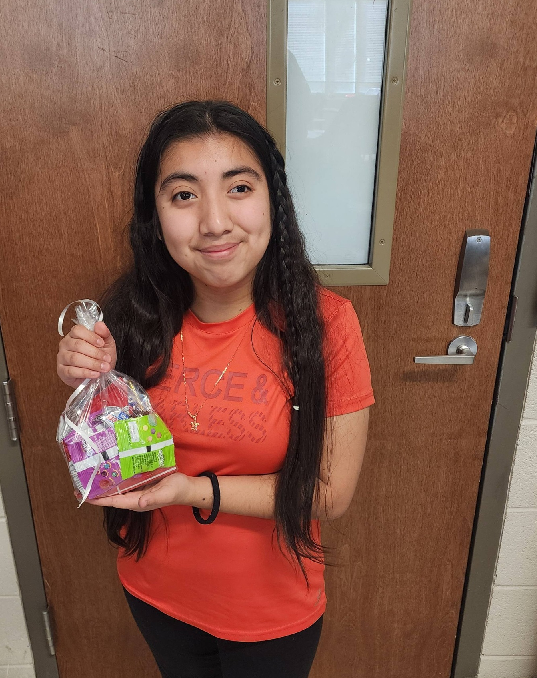 Ruby stands in front of a door holding her treats