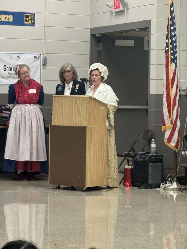 DAR speakers presenting in the cafeteria.