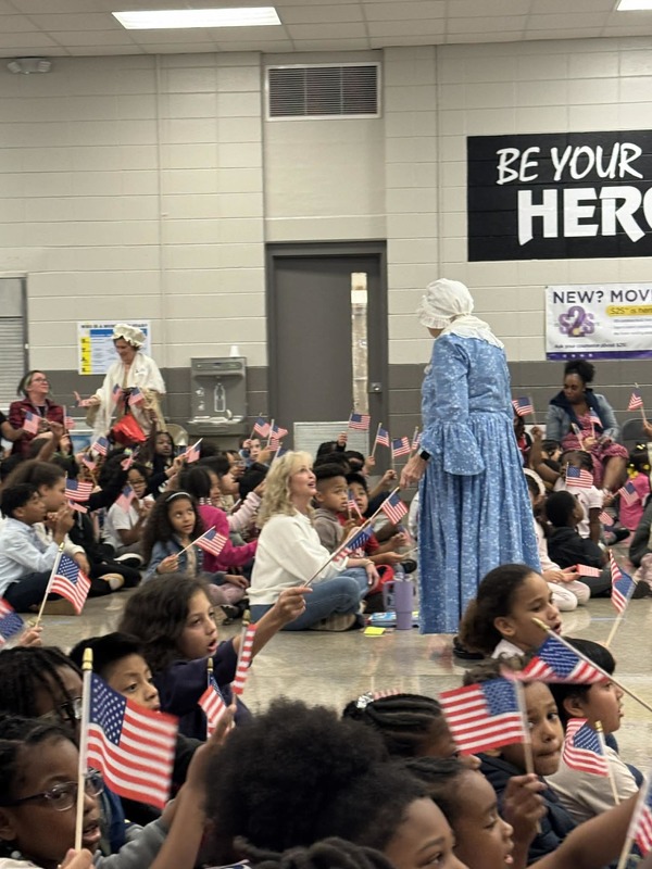 DAR presenters giving out American Flags to students.