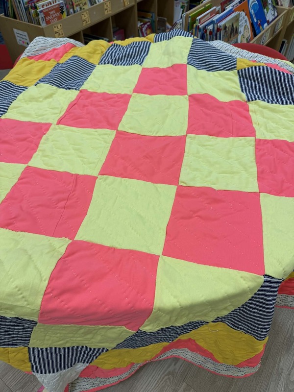 A quilt that is green and pink checkered.
