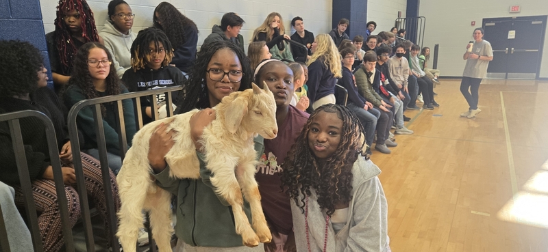 Students hold a goat as they learned about agriscience in the NCTHS gym.