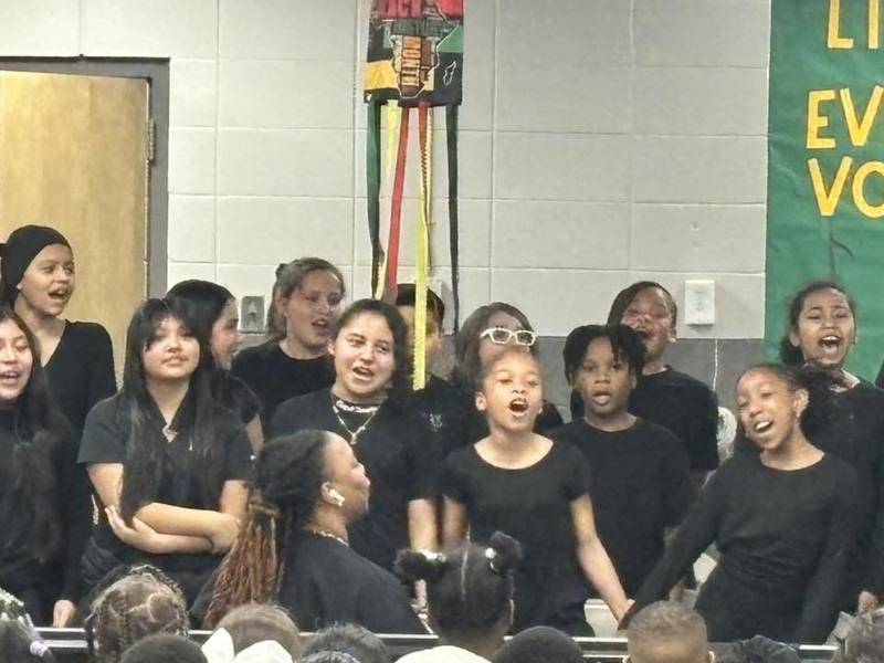 Students hand in hand singing together