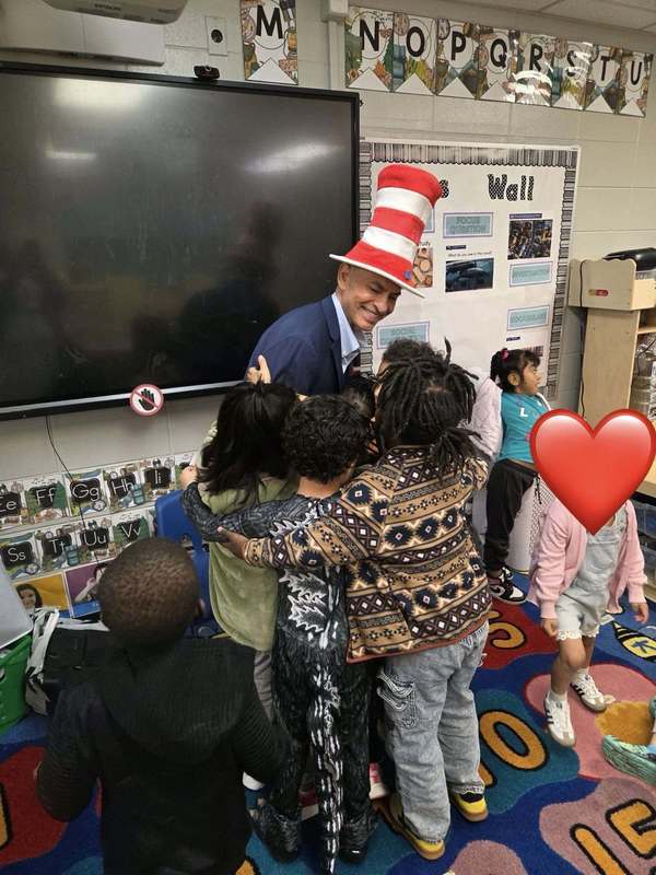 PreK students hugging guest reader