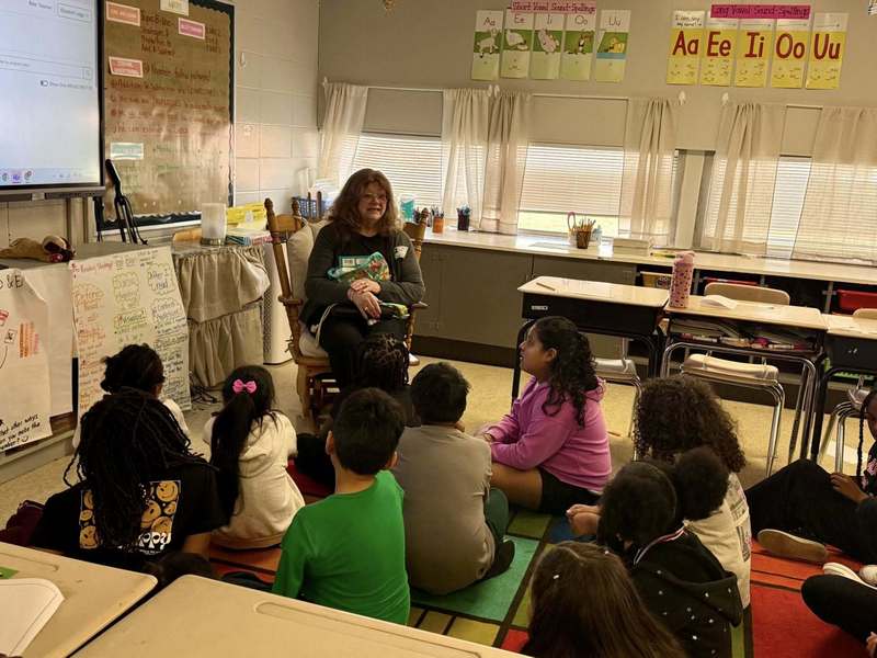 Retired teacher and DKG member reading to a third grade class