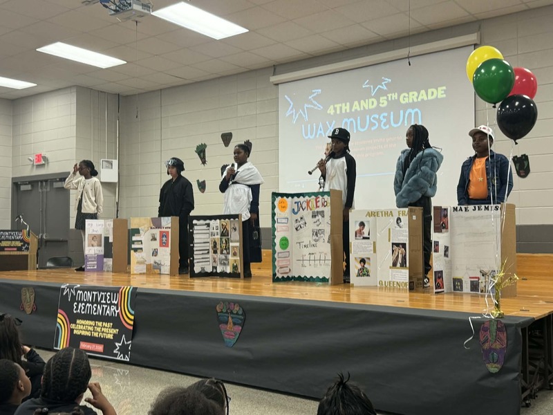 4th and 5th graders on stage showing a preview of their Wax Museums.