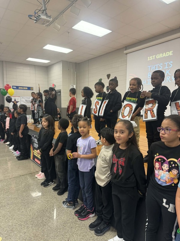 First grade performing "This is Black History" with signs spelling out Black History.