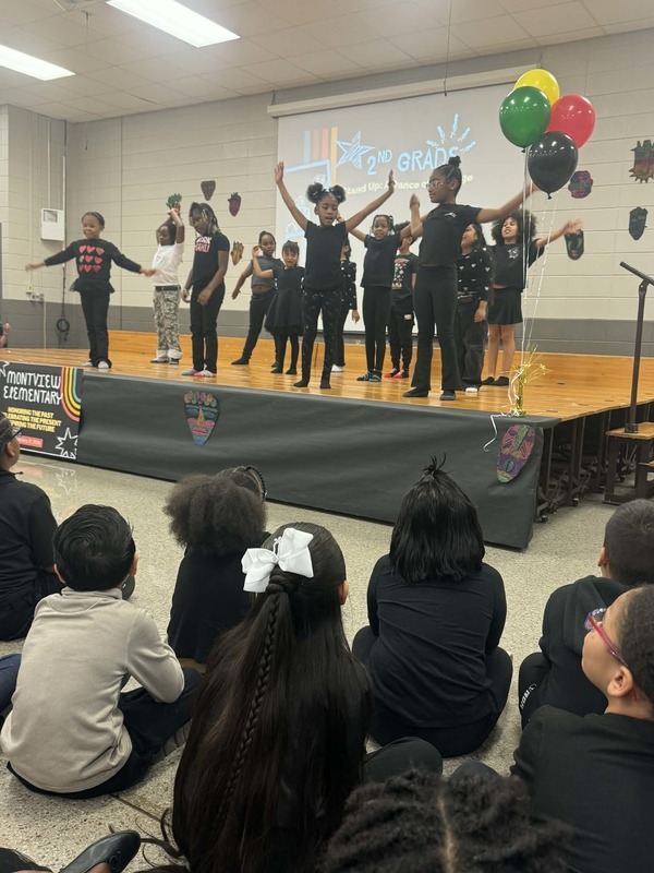 Second grade students on stage performing their dance routine. 