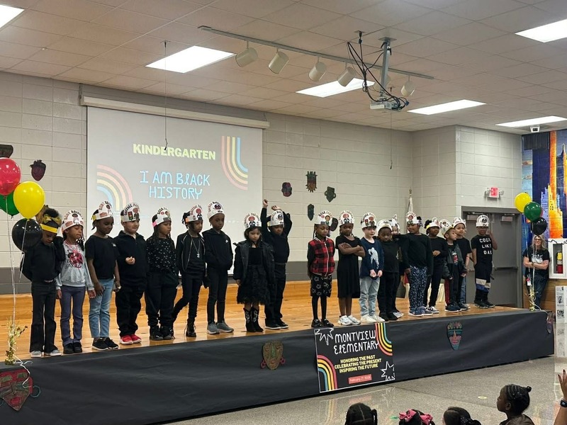 Kindergarted performing "I Am Black History" with their hand-made hats.