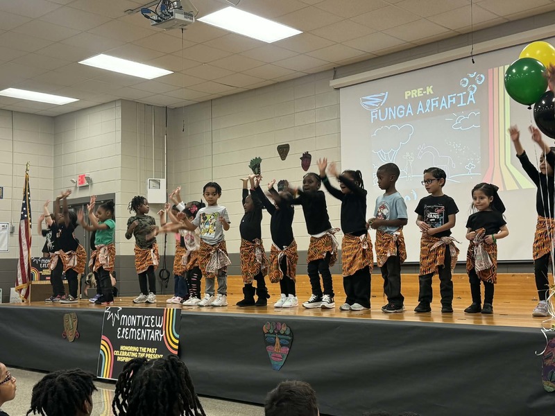 Pre-K performing "Funga Alfalfia" with African skirts.