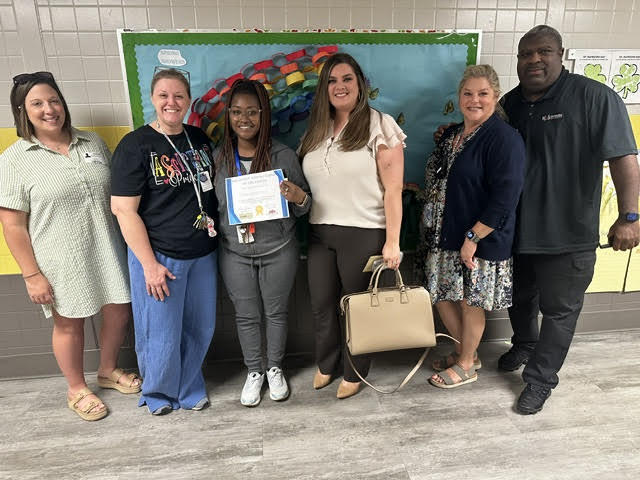 Miss K receiving her award with Admininstration and community partners. 