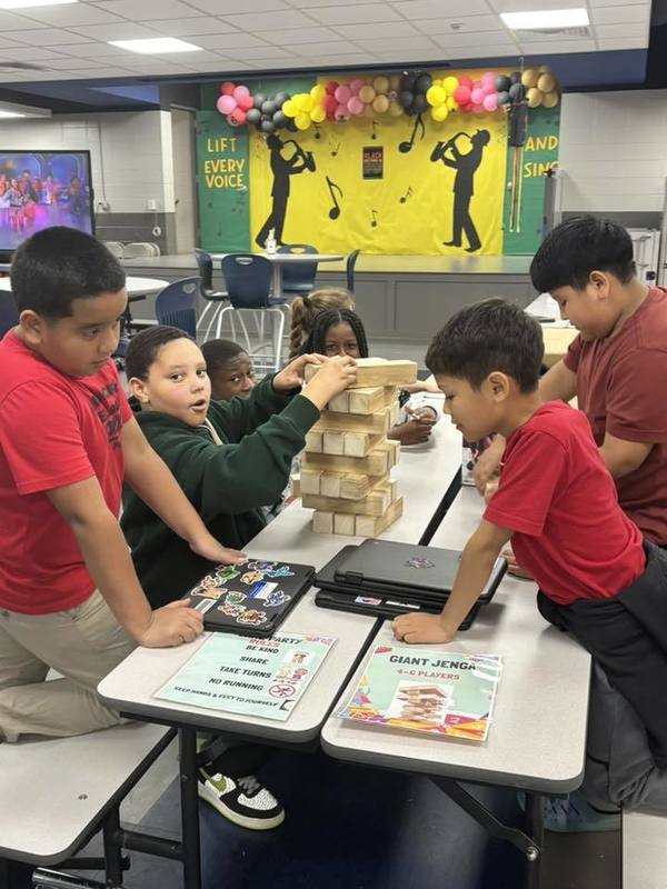 Fourth graders playing Jenga at the celebration.