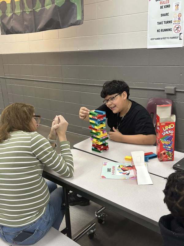 Ms. Ledyard and student playing Uno Stacko.