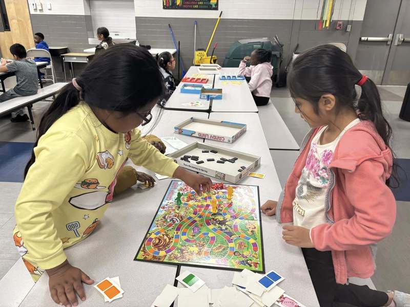 Two second graders very intently playing Candyland at the celebration.