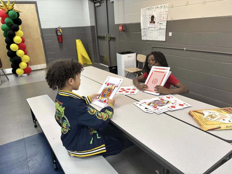 Two second graders with huge playing cards.