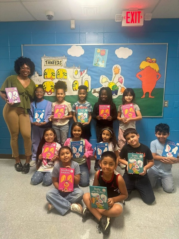 Ms. Brewer's Second Grade Class holding up their Dr. Seuss books in the hallway.
