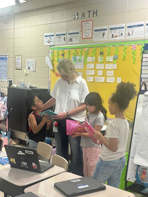 Assistant Principal Ms. Boissel giving out Dr. Seuss books to second graders.