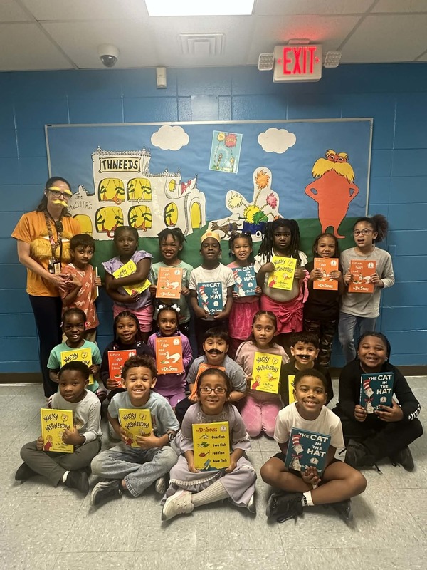 Miss Bordelon's First Grade Class holding up their new Dr. Seuss books.