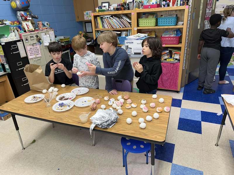 students standing at table making seed bombs