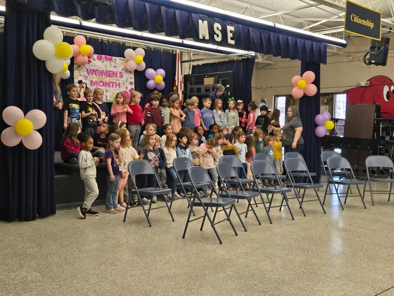 students on stage performing for program
