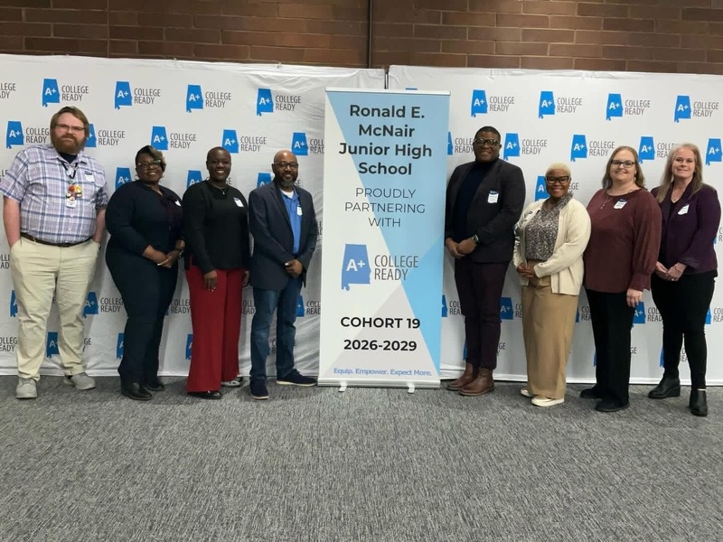 McNair school staff pose with district staff in front of the A+ College Ready Cohort 19 2026-2029 banner