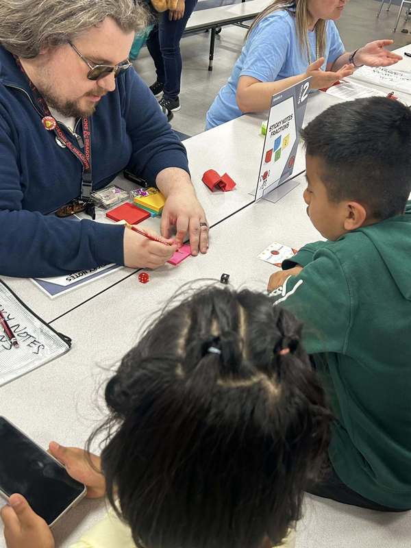 Mr. Whetstone helping students with a math game.