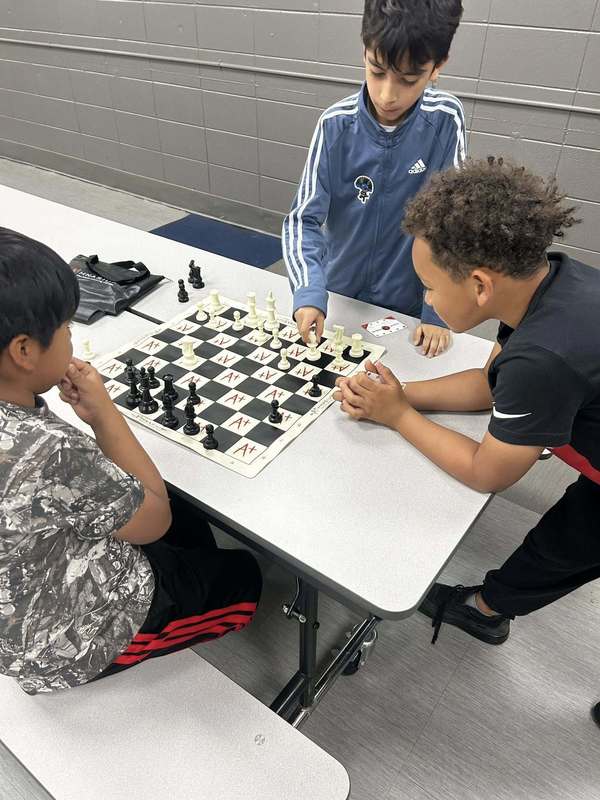 Third grade boys playing chess provided by Mathnasium
