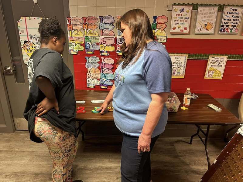 Mrs. Noworyta and a student working on a literacy activity