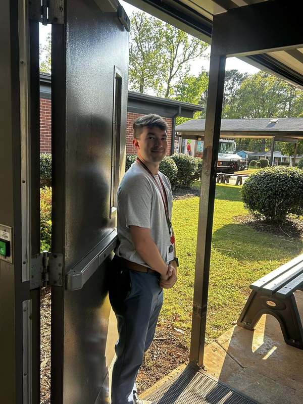 Coach Meadows greeting families as they arrive to Family Fun Night