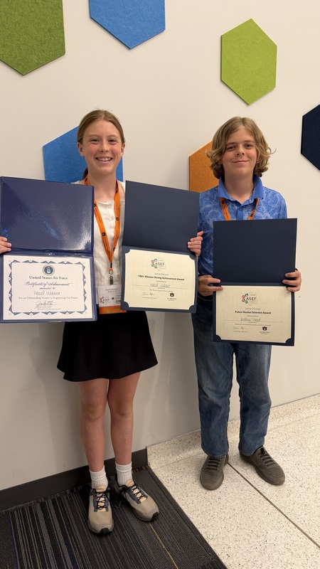 Hazel and Drew at the state science fair with their awards.