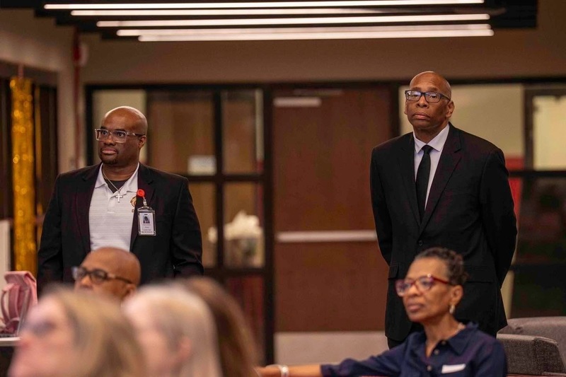 Dr. Richey, principal and Dr. Sutton, superintendent  both wearing dark colored suits and standing behind people sitting in the Innovation Center at Columbia.