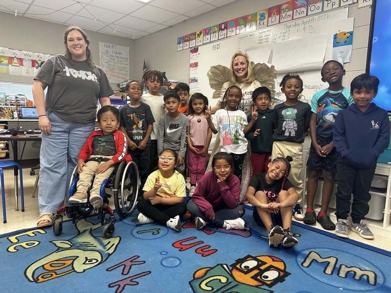 Ms. Howard's class and the president of The Caring Link dressed as The Book Fairy.