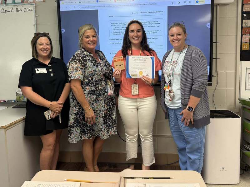 Admin and a community member presenting Ms. Moody with her certificate and gift card.