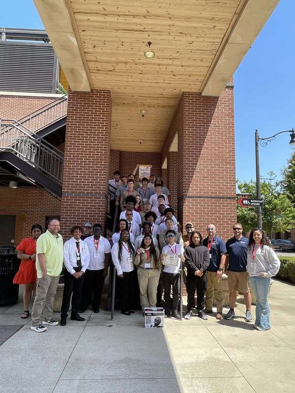 All of the Huntsville City Schools students and advisors who attended SkillsUSA stand on stairs and smile.