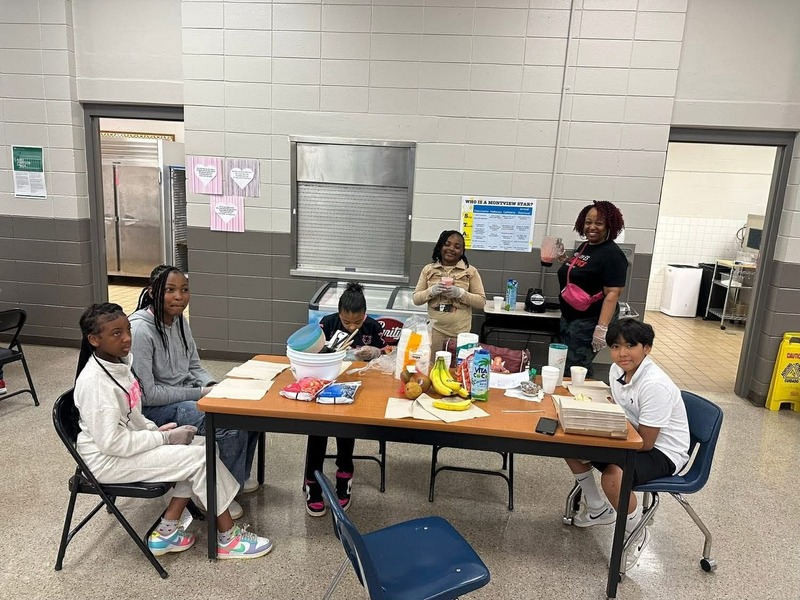 Students and Ms. Thomas in the cafeteria making waffles during their Cooking Club.