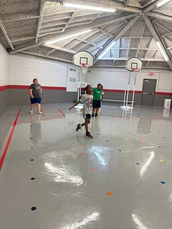 Students playing basketball in the gym for Basketball Club.