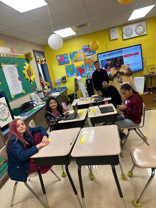 Students with Ms. Phillips smiling during their Orimami Club.