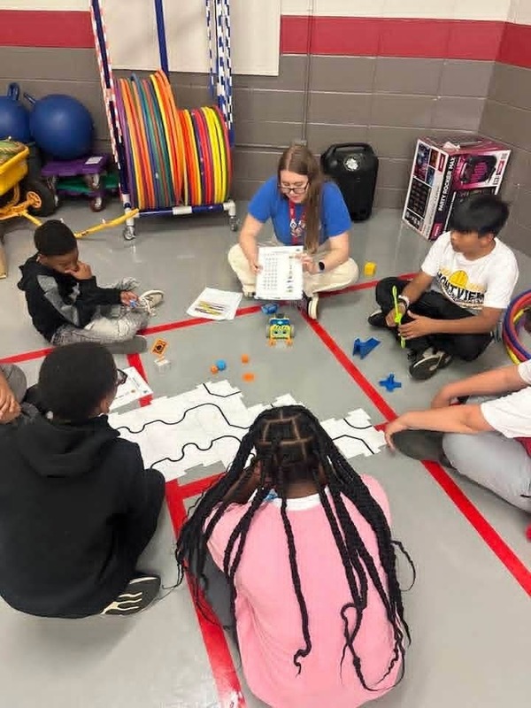 5th grade students using code for a robot at the Botley 2.0 & VEX Aim Robotics Station.