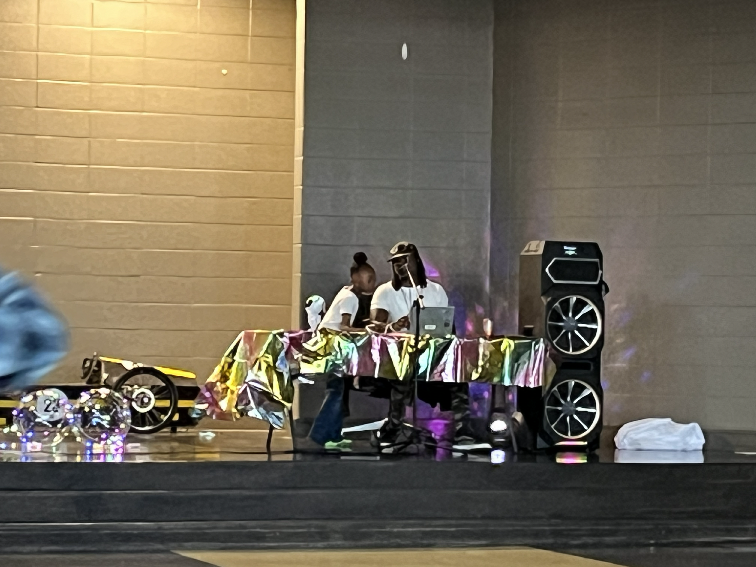 Mr. Palmer and his assistant (Mrs. Parrish's 6 year old daughter)  sit behind the DJ booth at our Eagles Night Under the Stars Spring Dance