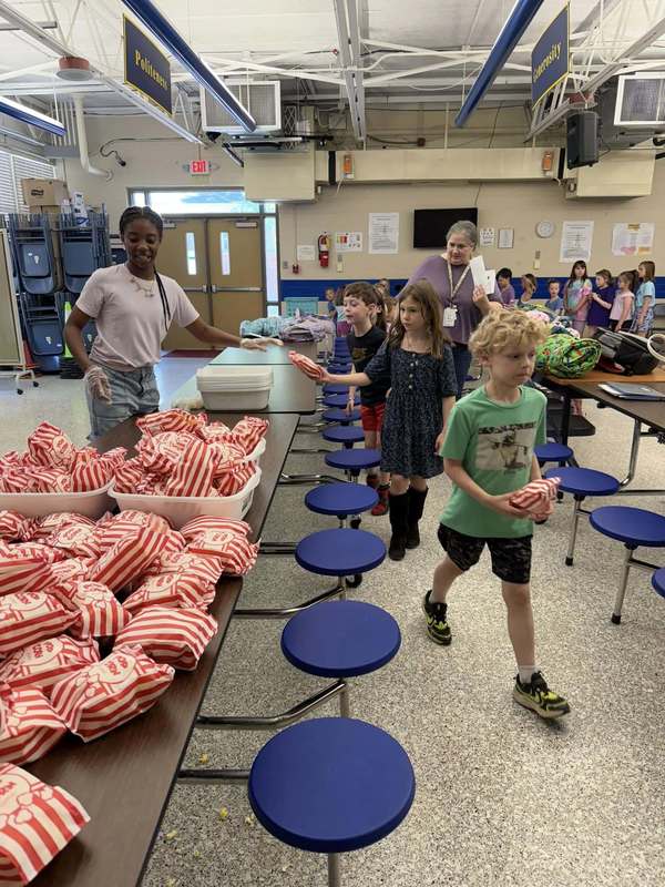 students in line to get popcorn for movie party