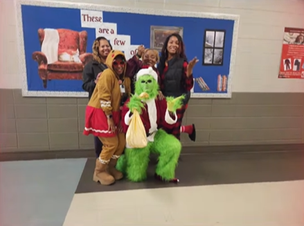 Dr. Burruss posing with Stallworth-Brown and Lattimore, Mrs. Jones (as a gingerbread lady) and Mr. Palmer (as the Grinch)