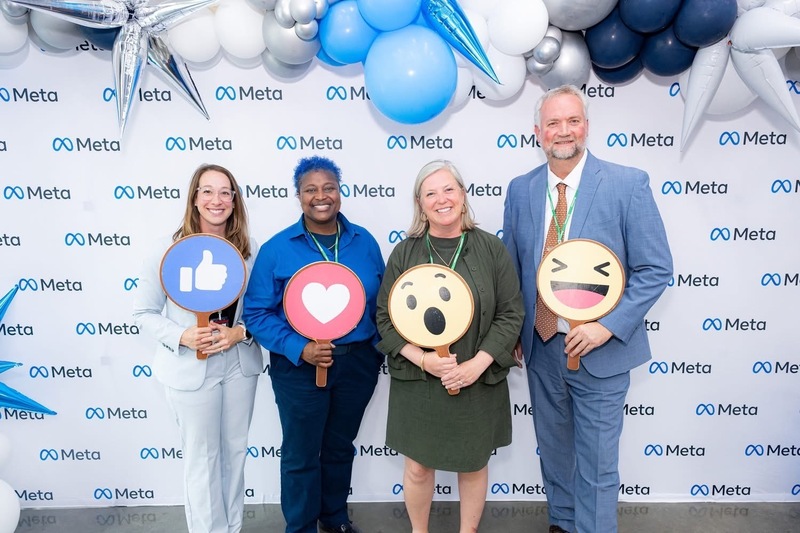 HCS staff holding cardboard META Interaction signs, such as the blue Thumbs Up and a red Heart symbol